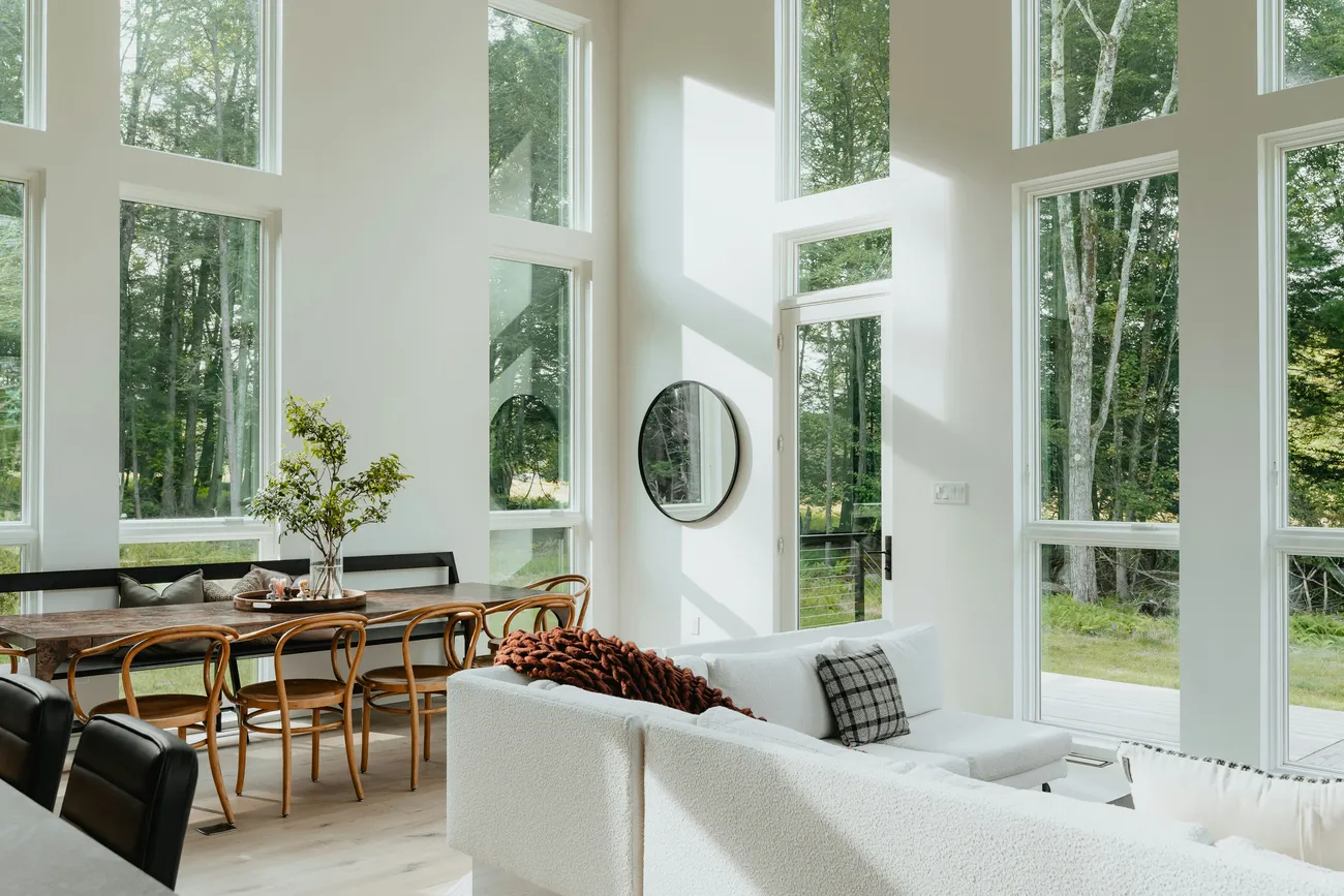 Salón con grandes ventanales y vistas al jardín en una casa de lujo
